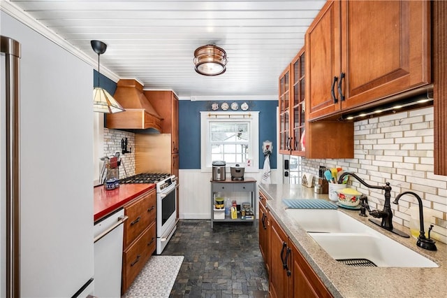 kitchen featuring light stone countertops, sink, pendant lighting, white appliances, and custom range hood