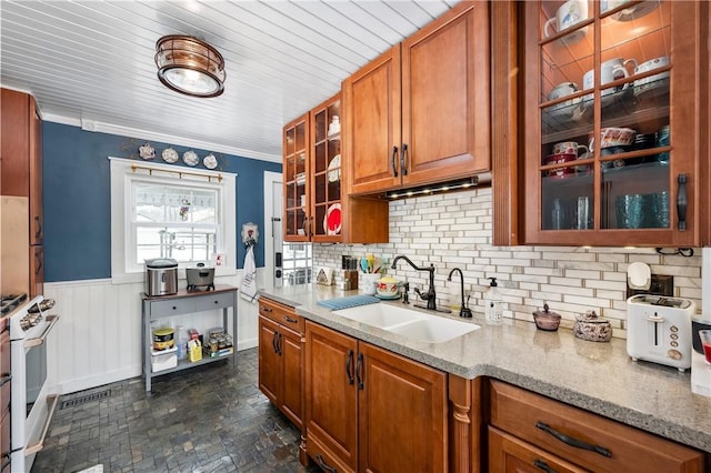 kitchen with decorative backsplash, light stone counters, ornamental molding, white range with gas cooktop, and sink