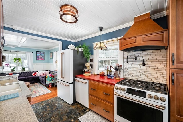 kitchen featuring premium range hood, ornamental molding, pendant lighting, and premium appliances