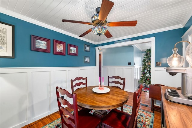 dining space featuring hardwood / wood-style floors, ceiling fan, and crown molding