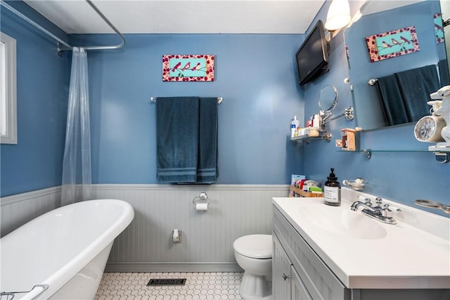 bathroom with tile patterned flooring, a bath, vanity, and toilet