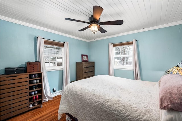 bedroom featuring hardwood / wood-style floors, a baseboard heating unit, ceiling fan, and ornamental molding