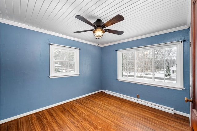 empty room featuring a wealth of natural light, ceiling fan, baseboard heating, light wood-type flooring, and ornamental molding