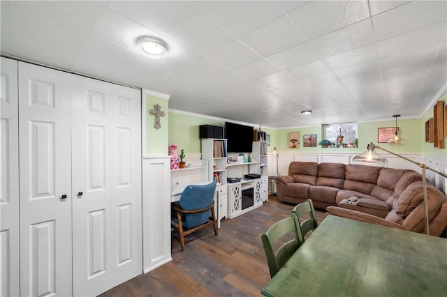 living room with dark hardwood / wood-style flooring and ornamental molding