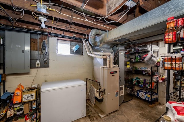 basement featuring refrigerator, electric panel, and heating unit