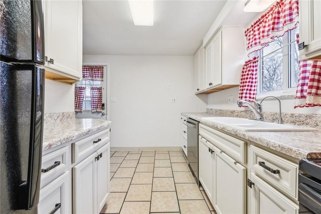 kitchen featuring white cabinetry, sink, light tile patterned flooring, and stainless steel appliances