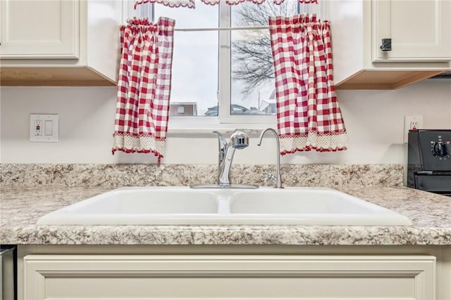 interior details featuring light stone counters and sink