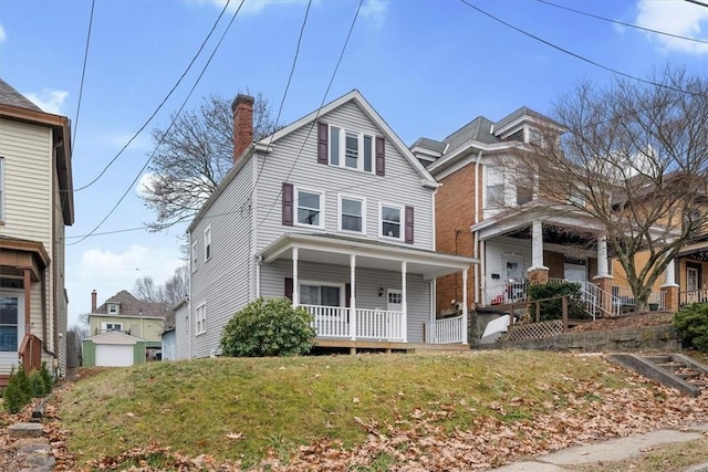 view of property featuring covered porch and a front lawn