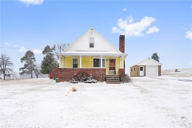 view of front of home with a porch, a garage, and an outbuilding