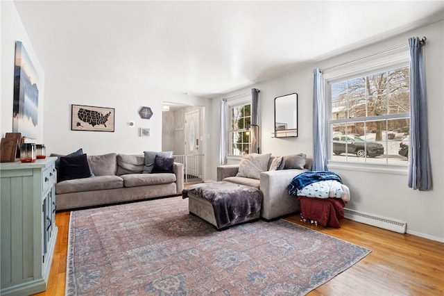 living room featuring wood-type flooring and a baseboard heating unit