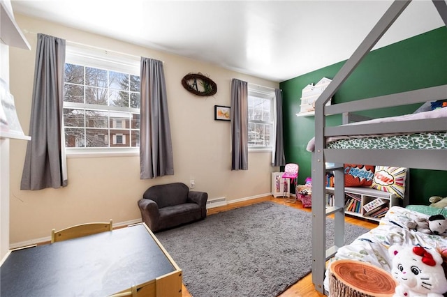 bedroom featuring baseboard heating and hardwood / wood-style floors