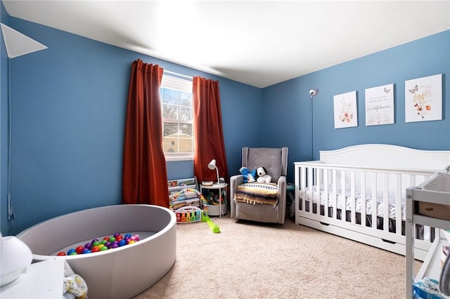 carpeted bedroom featuring a crib