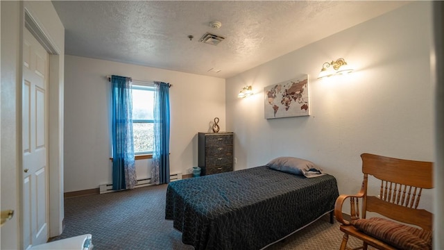 bedroom with carpet, a textured ceiling, a closet, and a baseboard heating unit