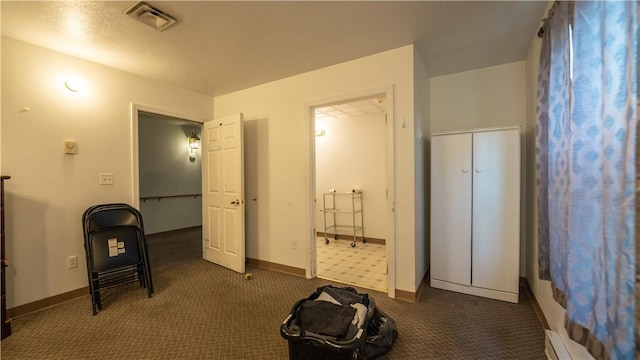 carpeted bedroom featuring a baseboard heating unit