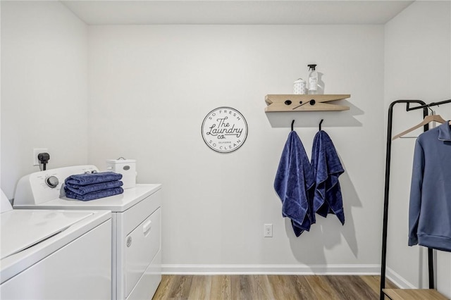 laundry area with washer and clothes dryer and hardwood / wood-style floors