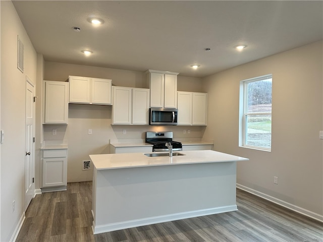 kitchen featuring sink, white cabinets, hardwood / wood-style flooring, a kitchen island with sink, and stainless steel appliances