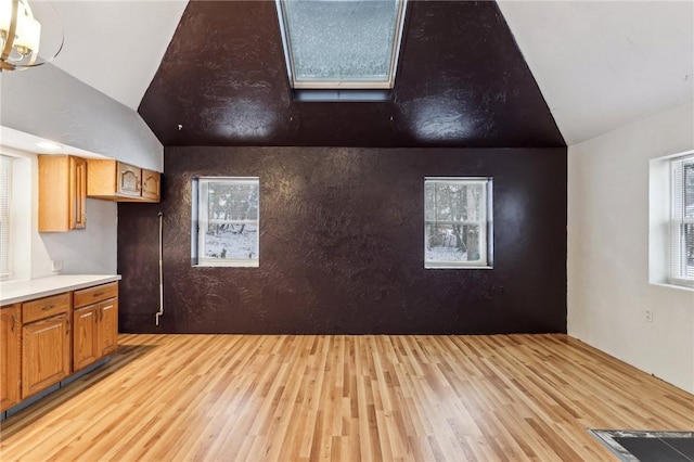 additional living space with lofted ceiling and light hardwood / wood-style floors