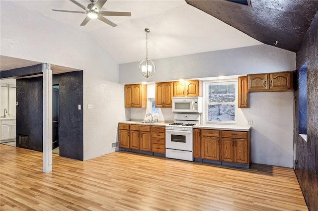 kitchen featuring decorative light fixtures, sink, ceiling fan, white appliances, and light hardwood / wood-style flooring