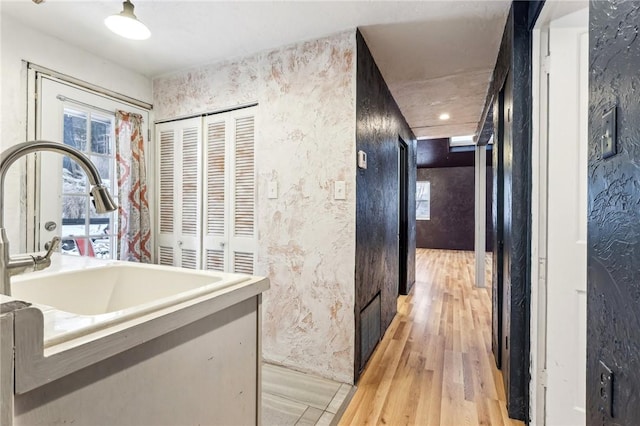 hallway with sink and light hardwood / wood-style floors