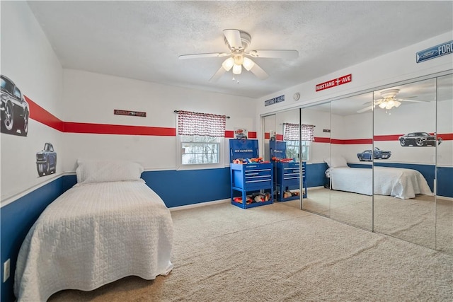 carpeted bedroom featuring ceiling fan, a closet, and a textured ceiling