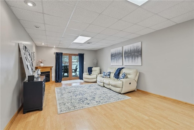 living room featuring a paneled ceiling and hardwood / wood-style floors