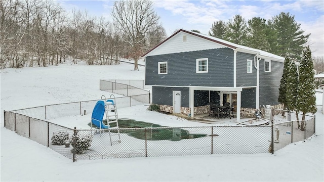 view of snow covered back of property