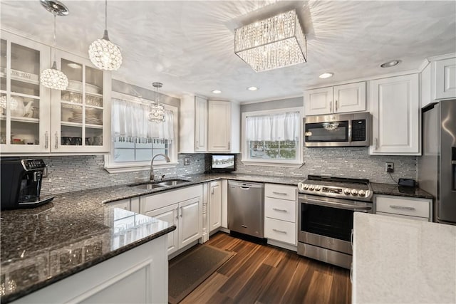 kitchen featuring sink, hanging light fixtures, dark hardwood / wood-style flooring, white cabinets, and appliances with stainless steel finishes