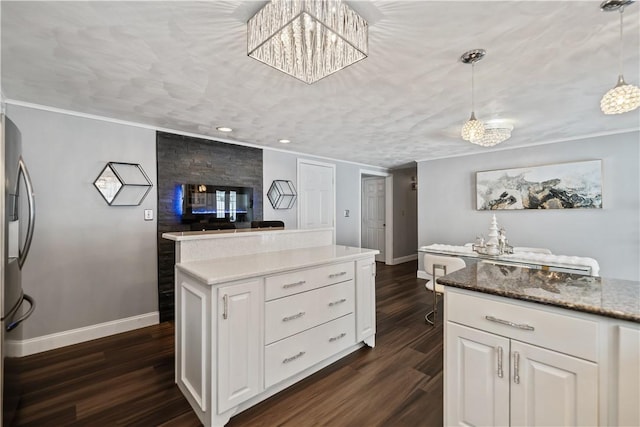 kitchen with white cabinets, decorative light fixtures, dark hardwood / wood-style flooring, and light stone countertops