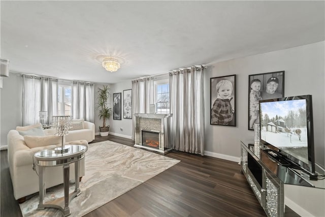 living room featuring a chandelier, dark wood-type flooring, and a healthy amount of sunlight