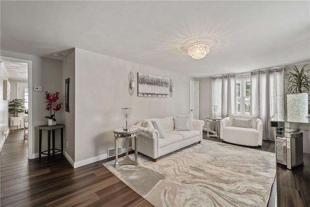 living room featuring dark hardwood / wood-style flooring and a notable chandelier