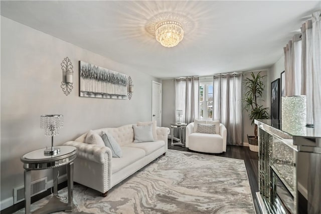 living room with hardwood / wood-style floors and an inviting chandelier