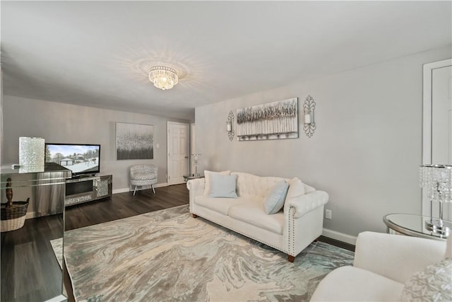 living room featuring dark wood-type flooring and an inviting chandelier