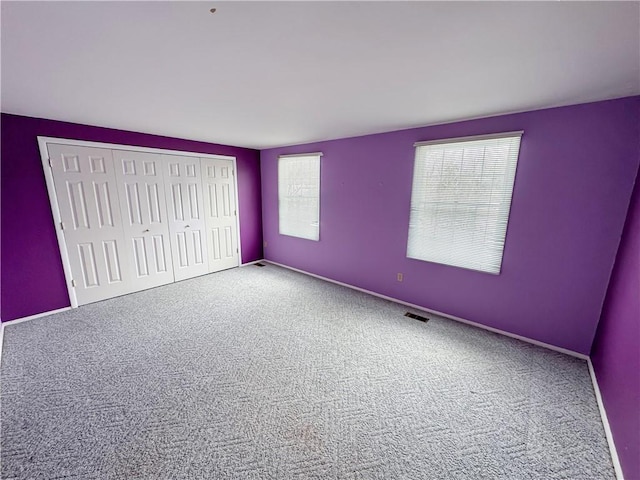 unfurnished bedroom featuring carpet and a closet