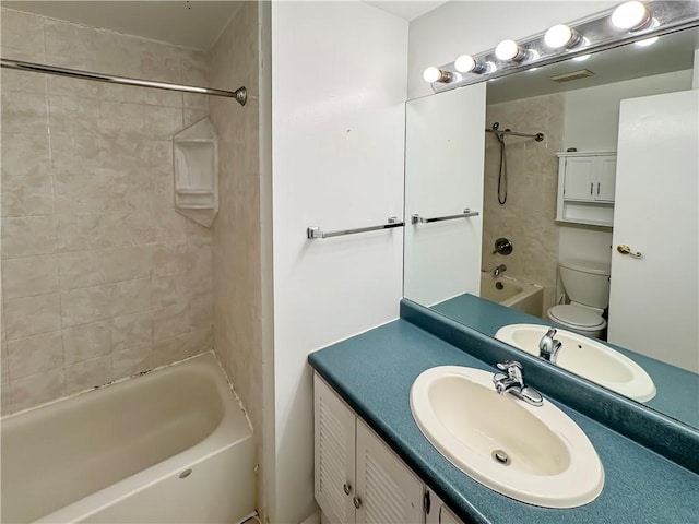 full bathroom featuring toilet, vanity, and tiled shower / bath