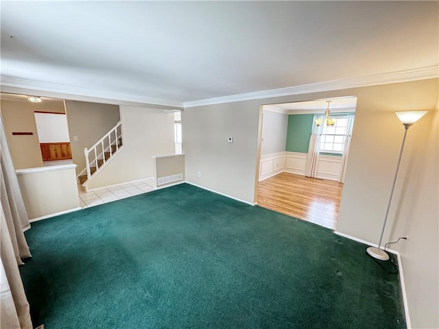 unfurnished living room with carpet floors, ornamental molding, and a notable chandelier