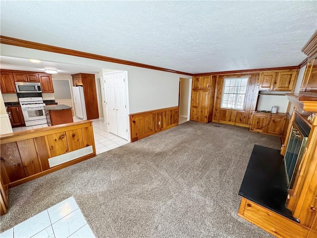 living room with wooden walls, crown molding, light colored carpet, and a textured ceiling