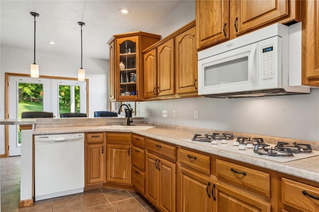 kitchen featuring sink, tile patterned flooring, kitchen peninsula, pendant lighting, and white appliances