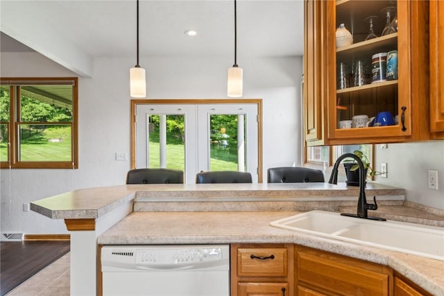 kitchen featuring white dishwasher, pendant lighting, and sink