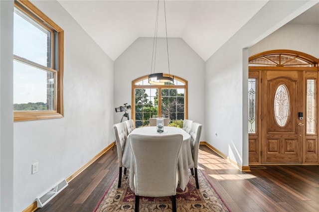 dining room with vaulted ceiling and dark wood-type flooring