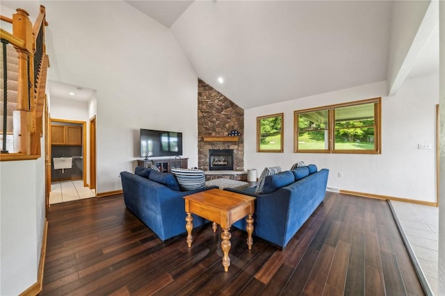 living room with hardwood / wood-style floors, high vaulted ceiling, and a stone fireplace