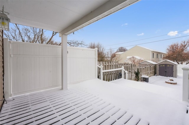 snow covered deck with a storage shed