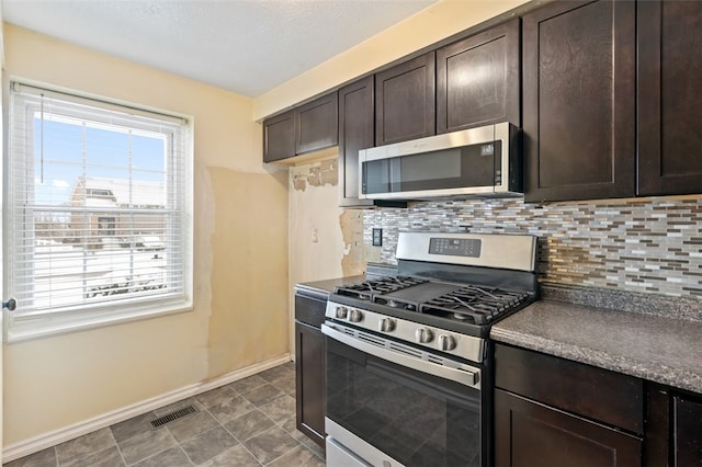 kitchen with dark brown cabinets, stainless steel appliances, and tasteful backsplash