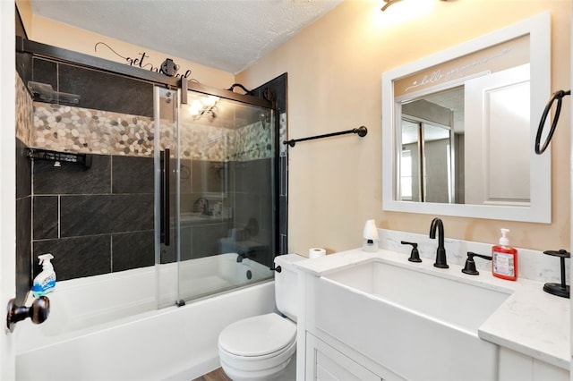 full bathroom with vanity, a textured ceiling, combined bath / shower with glass door, and toilet