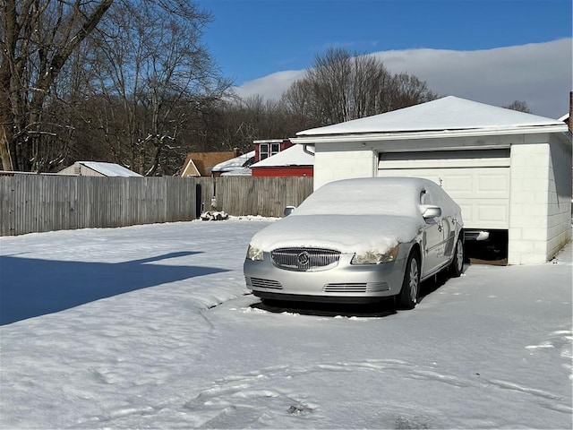 snow covered parking featuring a garage