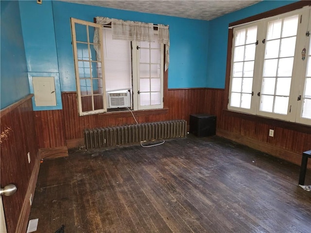 empty room with french doors, radiator, a textured ceiling, cooling unit, and dark hardwood / wood-style floors