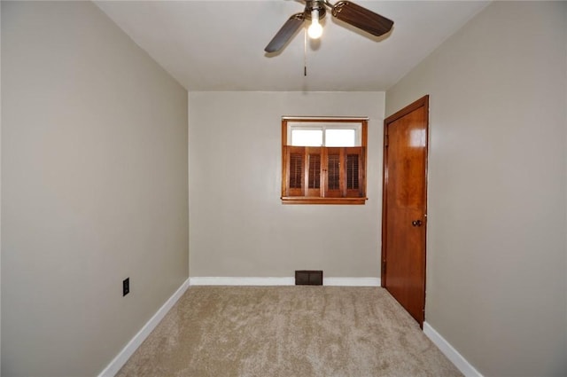 carpeted spare room featuring ceiling fan