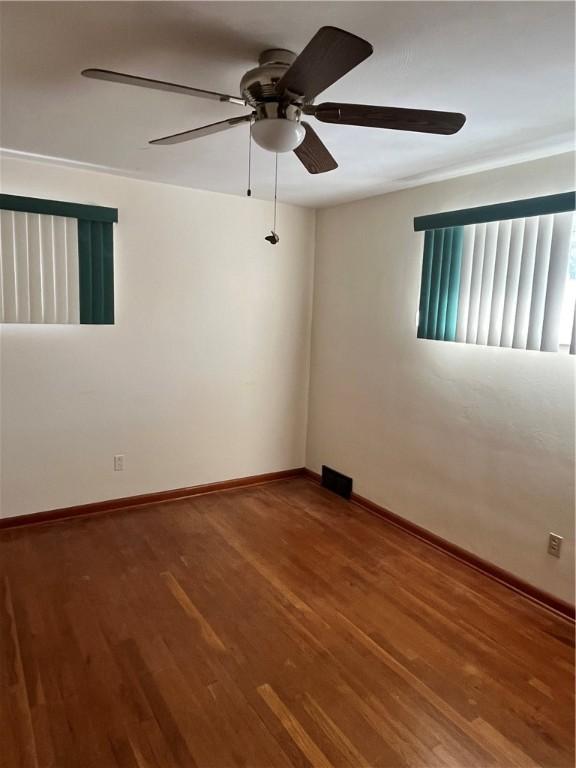 empty room with wood-type flooring and ceiling fan