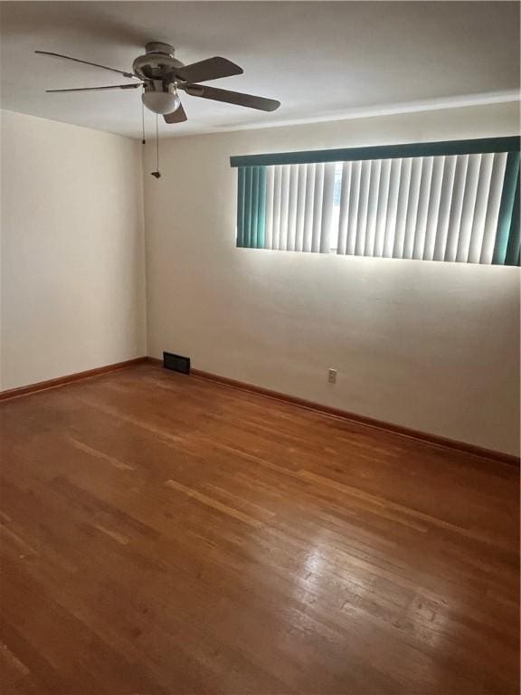 spare room featuring wood-type flooring and ceiling fan