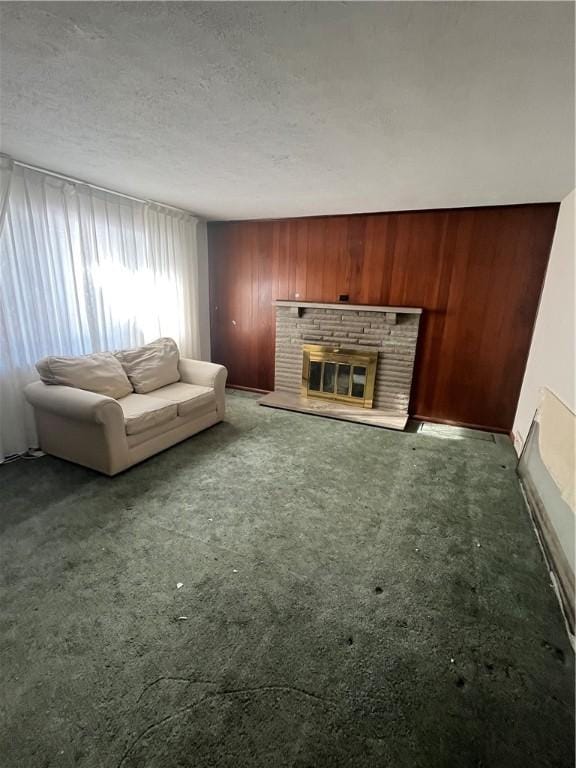 unfurnished living room featuring carpet flooring, a textured ceiling, wooden walls, and a brick fireplace