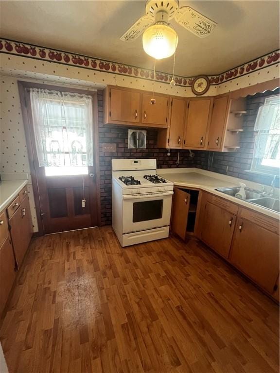 kitchen with ceiling fan, light hardwood / wood-style floors, white range with gas stovetop, and sink